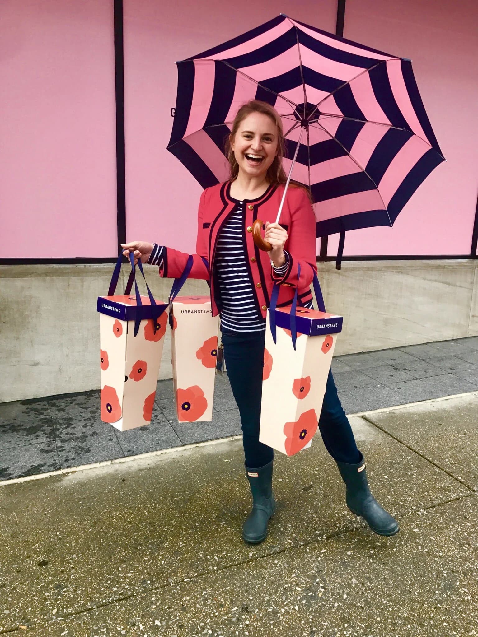 Woman with umbrella carrying UrbanStems bags