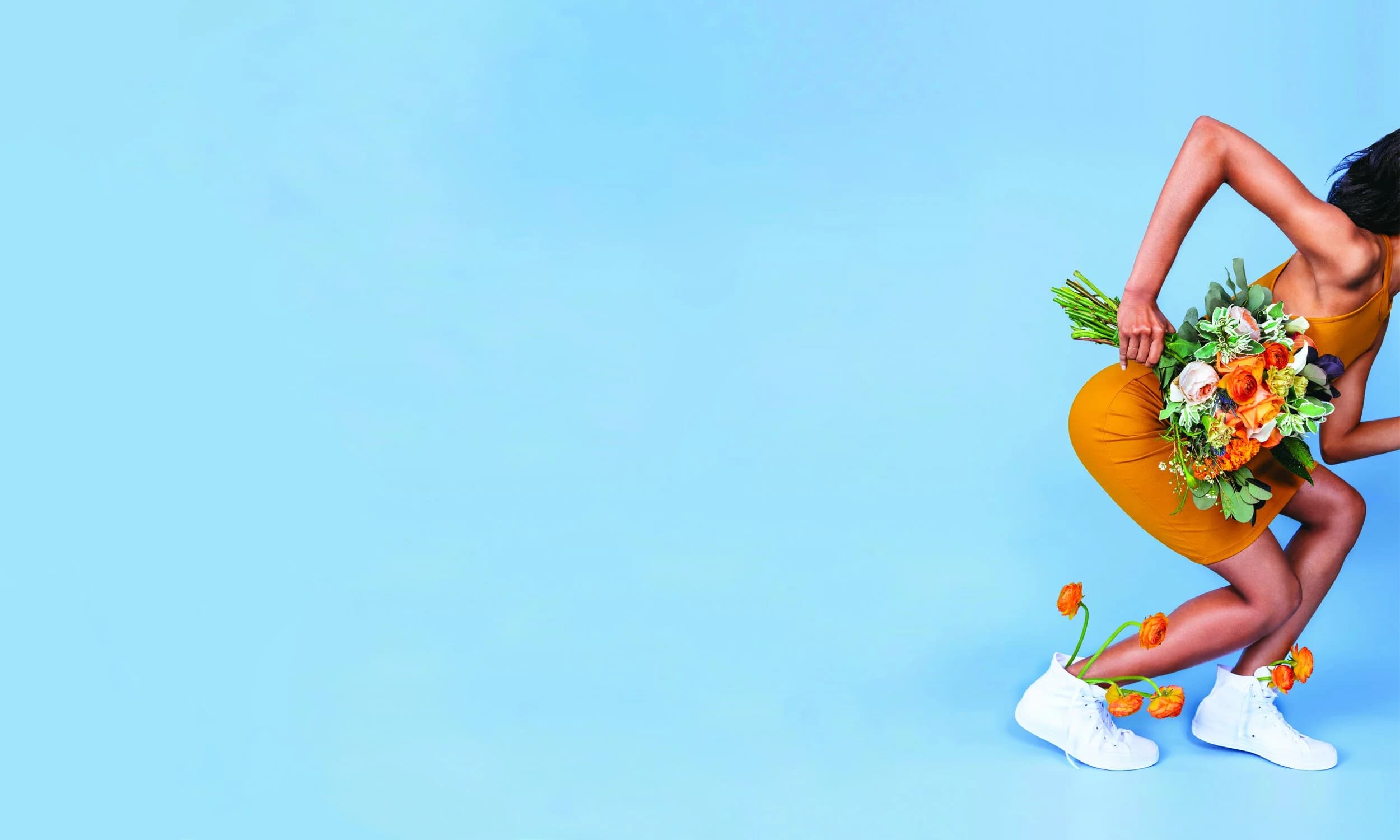 UrbanStems brand campaign — woman in orange dress with flowers